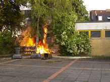Im Hofbereich des eingeschossigen Kindergarten-Gebudes schlagen Flammen vom Boden bis ber das Dach
